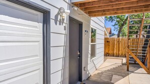 A garage door, a door with a peephole, a welcome mat, and a wooden fence. - 1brmodern & Chicdowntown OCC (Colorado Springs)