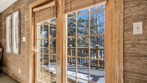 A wooden interior with large glass doors leading to a deck.