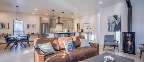 A modern living room with a leather sofa, a coffee table, and a fireplace.