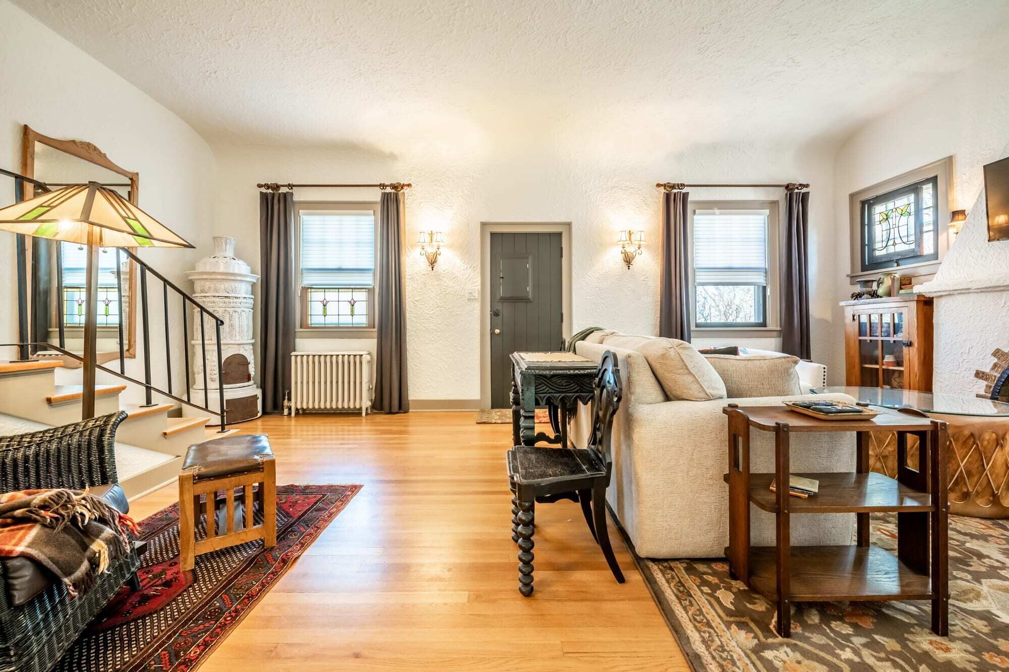 Een ruime woonkamer met een trap, een open haard en een gezellige zithoek.