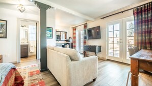 A spacious living room with a sofa, a dining table, and a kitchen area visible through an open door. - 5BD Houseblocks From Broadmoor Fireplacecheyenne Canon & Gorgeous Views! (Colorado Springs)