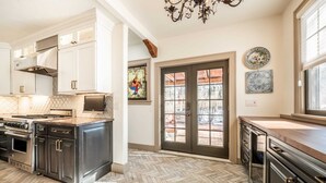 A kitchen with a herringbone floor, stainless steel appliances, white cabinetry, and a large window with a view. - 5BD Houseblocks From Broadmoor Fireplacecheyenne Canon & Gorgeous Views! (Colorado Springs)
