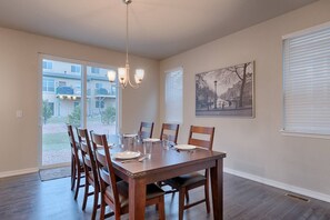 A dining area with a wooden table, six chairs, and a chandelier. - 3BR Mtn Viewsluxury Townhomecentral Locationac (Colorado Springs)