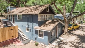 A two-story house with a steep roof, a visible chimney, and a small porch. - 3BR Manitou Springs2min to Restaurants W/hot Tub! (Manitou Springs)