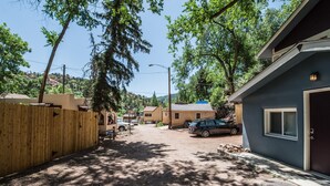 A residential street with houses, a wooden fence, and parked cars. - 3BR Manitou Springs2min to Restaurants W/hot Tub! (Manitou Springs)