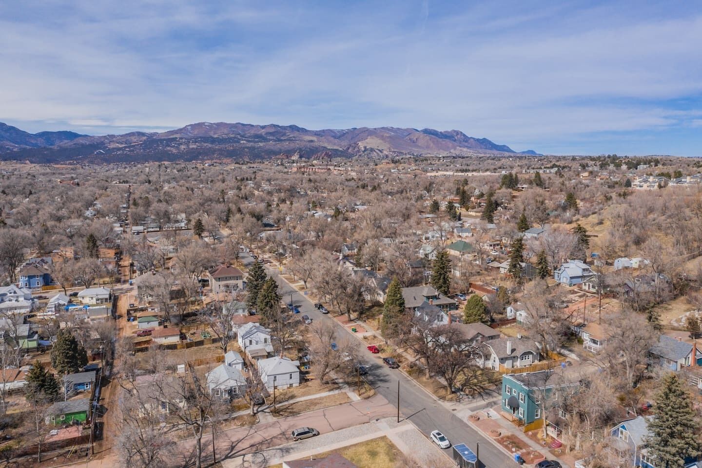 A residential area with houses, streets, and mountains in the background.