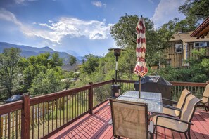 A deck with a table and chairs, overlooking a mountainous landscape. - 2brdowntown Occmountain Views & Grill (Colorado Springs)