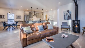 Un salon moderne avec un canapé en cuir, une table basse et une cheminée.