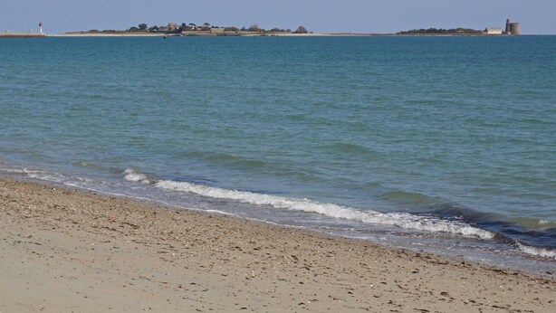 A beach with a lighthouse and a castle in the distance. - Elegant Modern House in St Vaast la Hougue (Saint-Vaast-la-Hougue)
