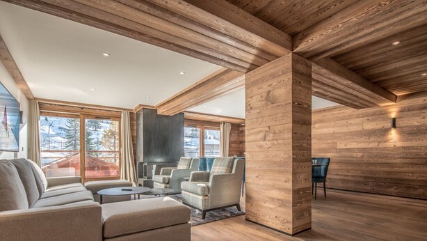 A spacious living room with a large sectional sofa, a fireplace, and a view of the outdoors. - Ski-in/Ski-out Apartment with Panoramic Views and Luxury Amenities in Méribel (Méribel)