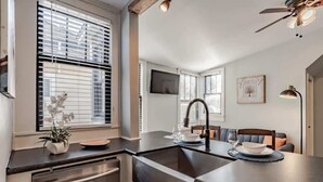 A modern kitchen with a central island, built-in dishwasher, and a dining area with a bench and table. - Mins from Downtown & Dining, Dauphin Darling 4 (Mobile)