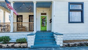 A house with a green door, white siding, and a porch with steps leading to the entrance. - Mins from Downtown & Dining, Dauphin Darling 4 (Mobile)