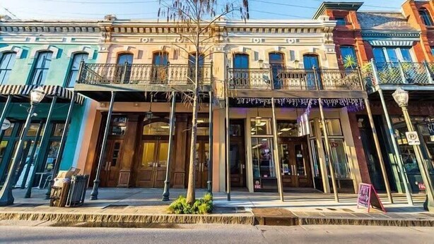 A row of colorful buildings with balconies and storefronts. - Mins from Downtown & Dining, Dauphin Darling 4 (Mobile)