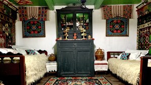 A traditional room with two wooden beds, a dark wooden cabinet, and a patterned rug. - Charming Traditional House in a Pristine Location (Fundata)