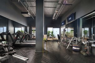 Una palestra moderna con tapis roulant, macchinari per pesi e uno specchio a parete.