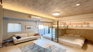 A compact room with bunk beds, a sofa, a small table, and a window with blinds. - Rakuten Stay Fukuoka - Yakuin (Fukuoka)