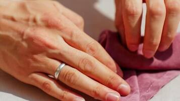 Hands holding a piece of fabric, possibly in the process of folding or handling it.