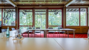 A conference room with a long table, chairs, and a red carpet. - Raststättenhotel Baden-Baden (Baden-Baden)