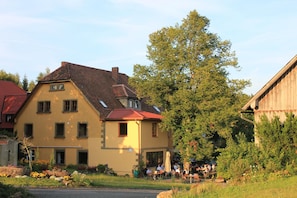 A two-story building with a sloped roof and multiple windows.