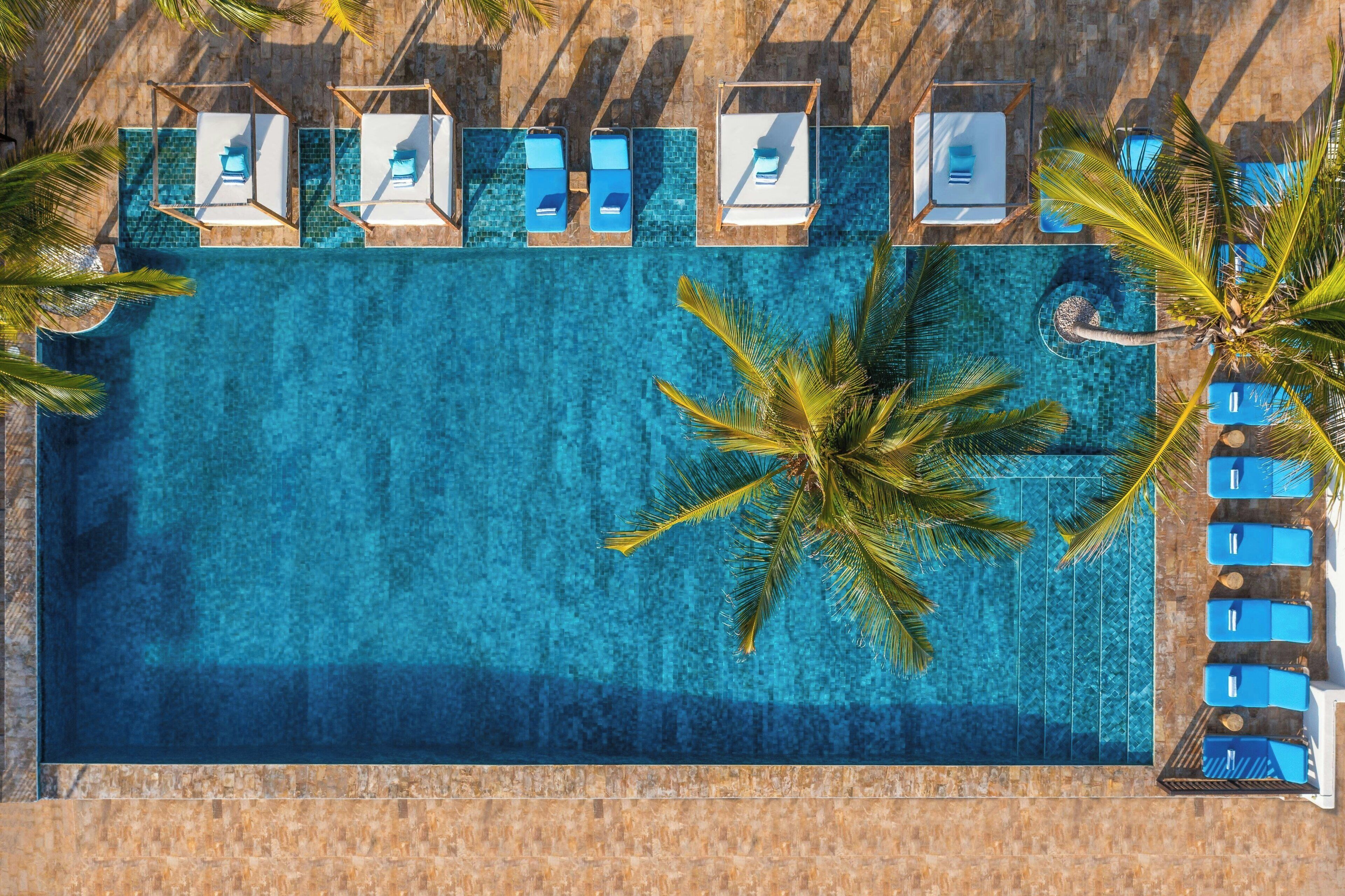 Una piscina al aire libre, camas de piscina gratis, sombrillas