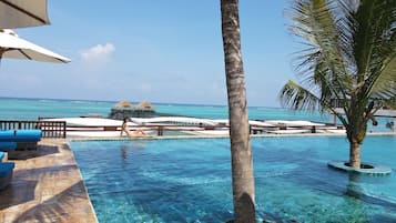 Una piscina al aire libre, camas de piscina gratis, sombrillas
