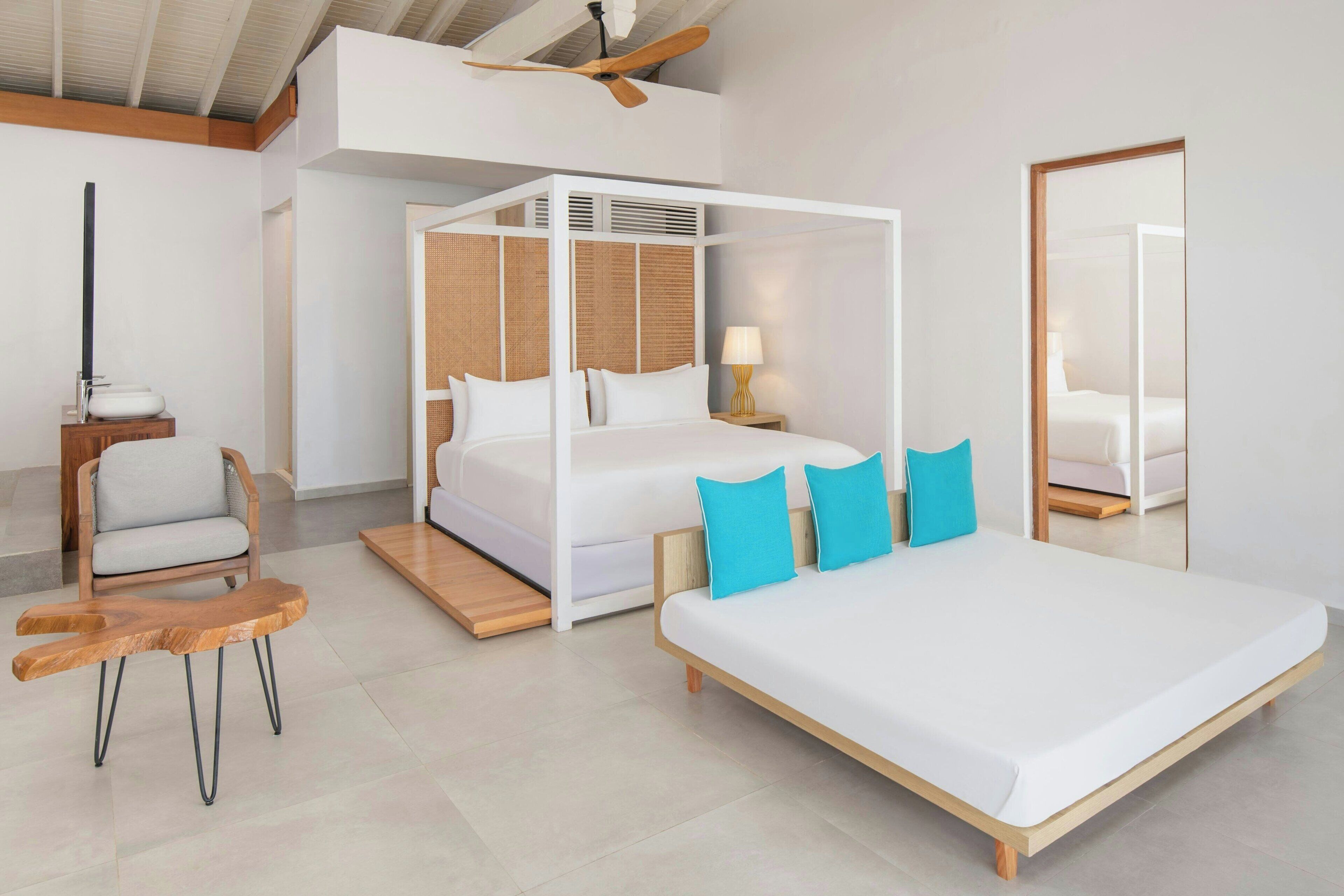 Un dormitorio moderno con una cama con dosel, una silla de madera y un espejo grande.