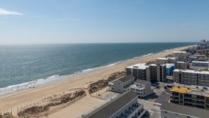 Un hotel frente al mar con varias construcciones, una playa y cielo despejado.