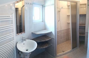 A bathroom with a white sink, a mirror, a shower enclosure, and a towel rack. - Beautiful 2-bed Apartment in Nin (Nin)