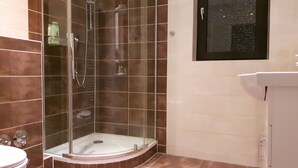 A shower area with a glass door, a toilet, and a sink. - Apartment in Bad Homburg, 2 rooms (Bad Homburg vor der Höhe)