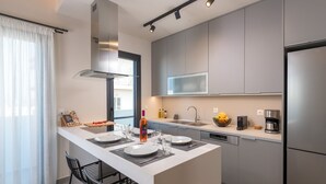 Een moderne keuken met een centraal eiland, roestvrijstalen apparatuur en een groot raam.