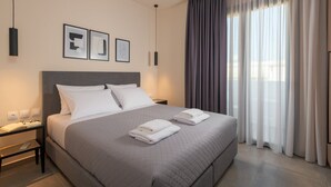 Een moderne hotelkamer met een groot bed, een nachtkastje en een raam met gordijnen.