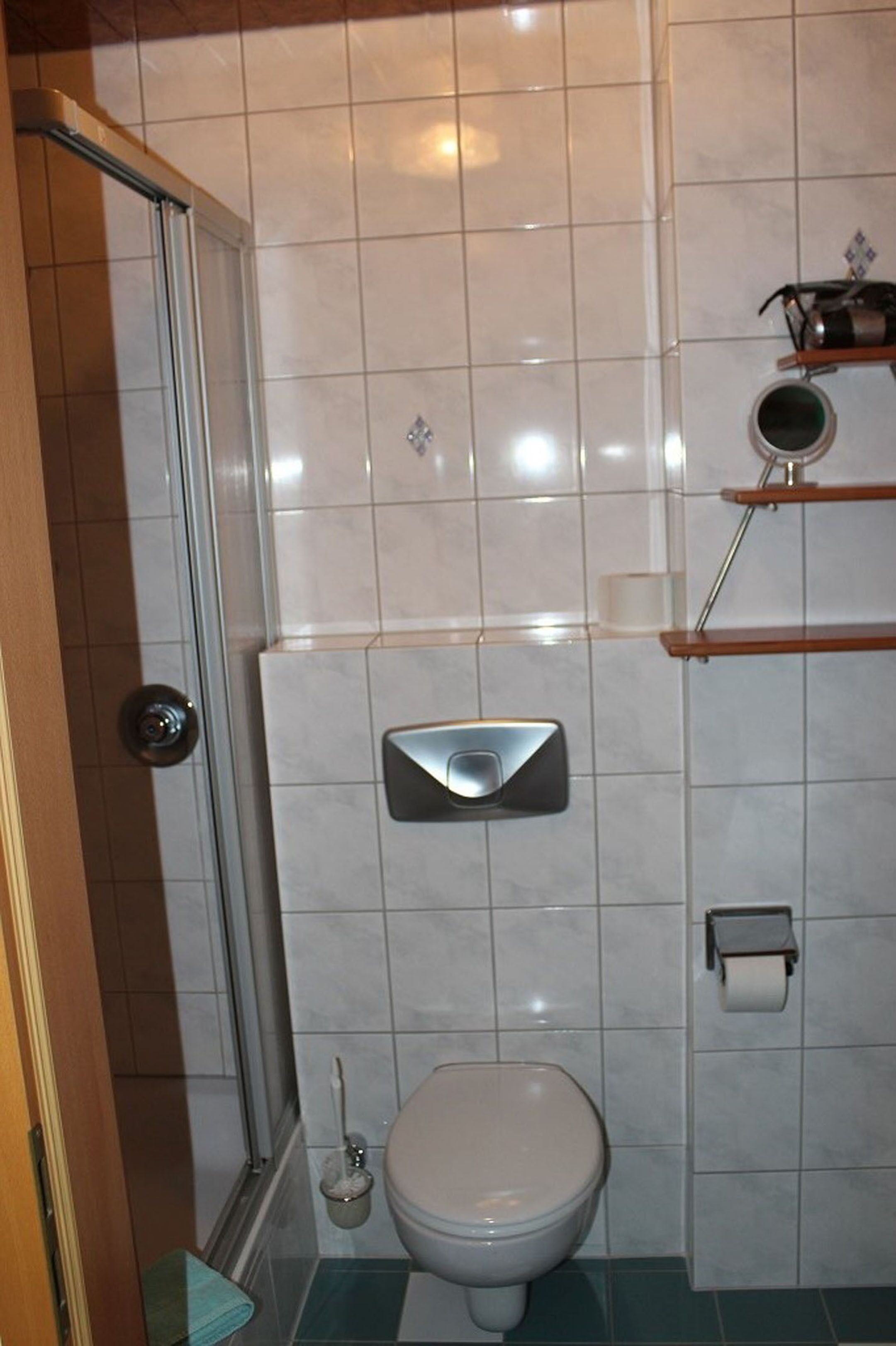 Un baño con inodoro, bidé, ducha y toallero.