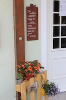 Un banco de madera con un cartel encima, una puerta y una ventana.