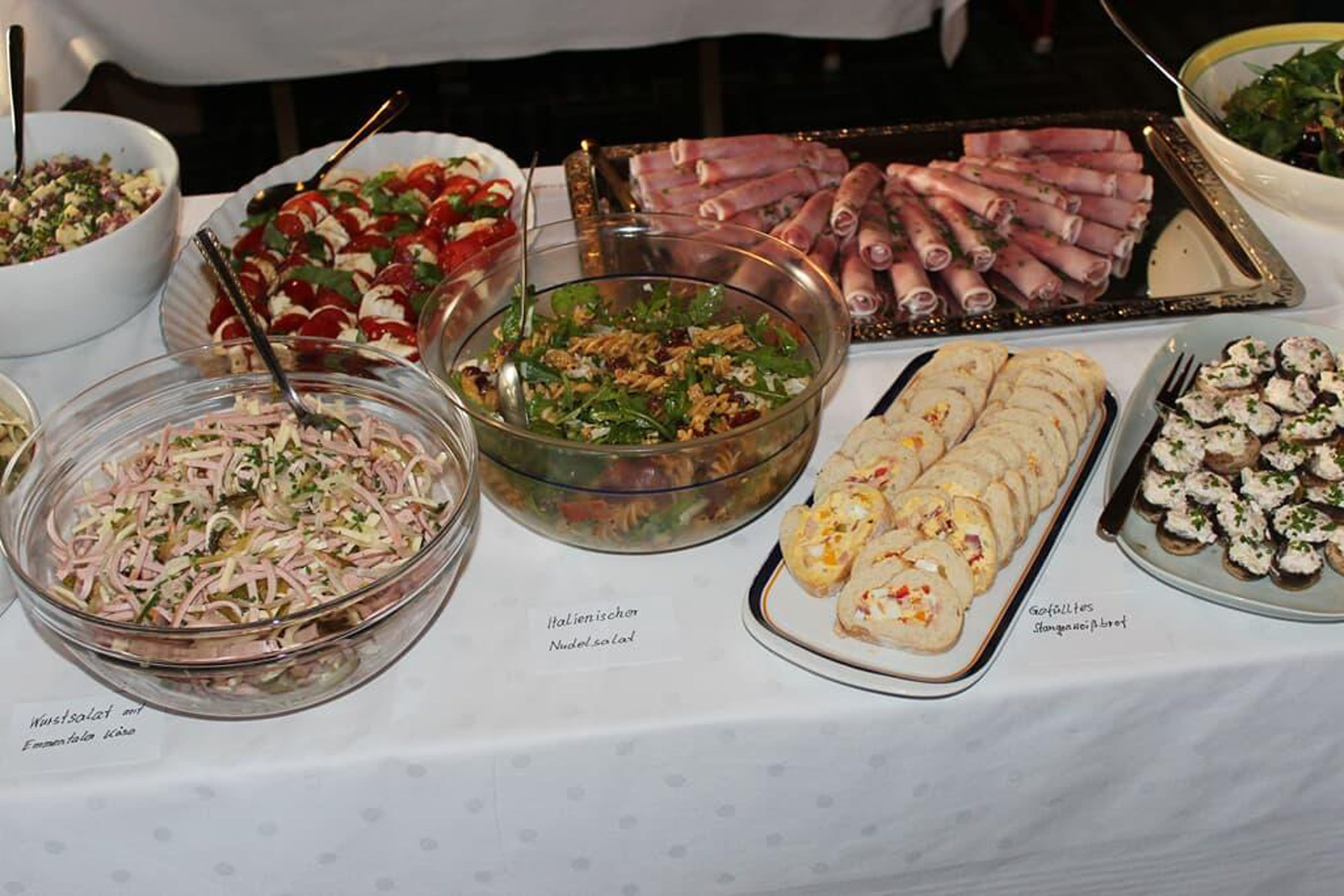 Un bufet de l'allau amb diversos plats, incloses amanides, carns arremolinades i sushi.