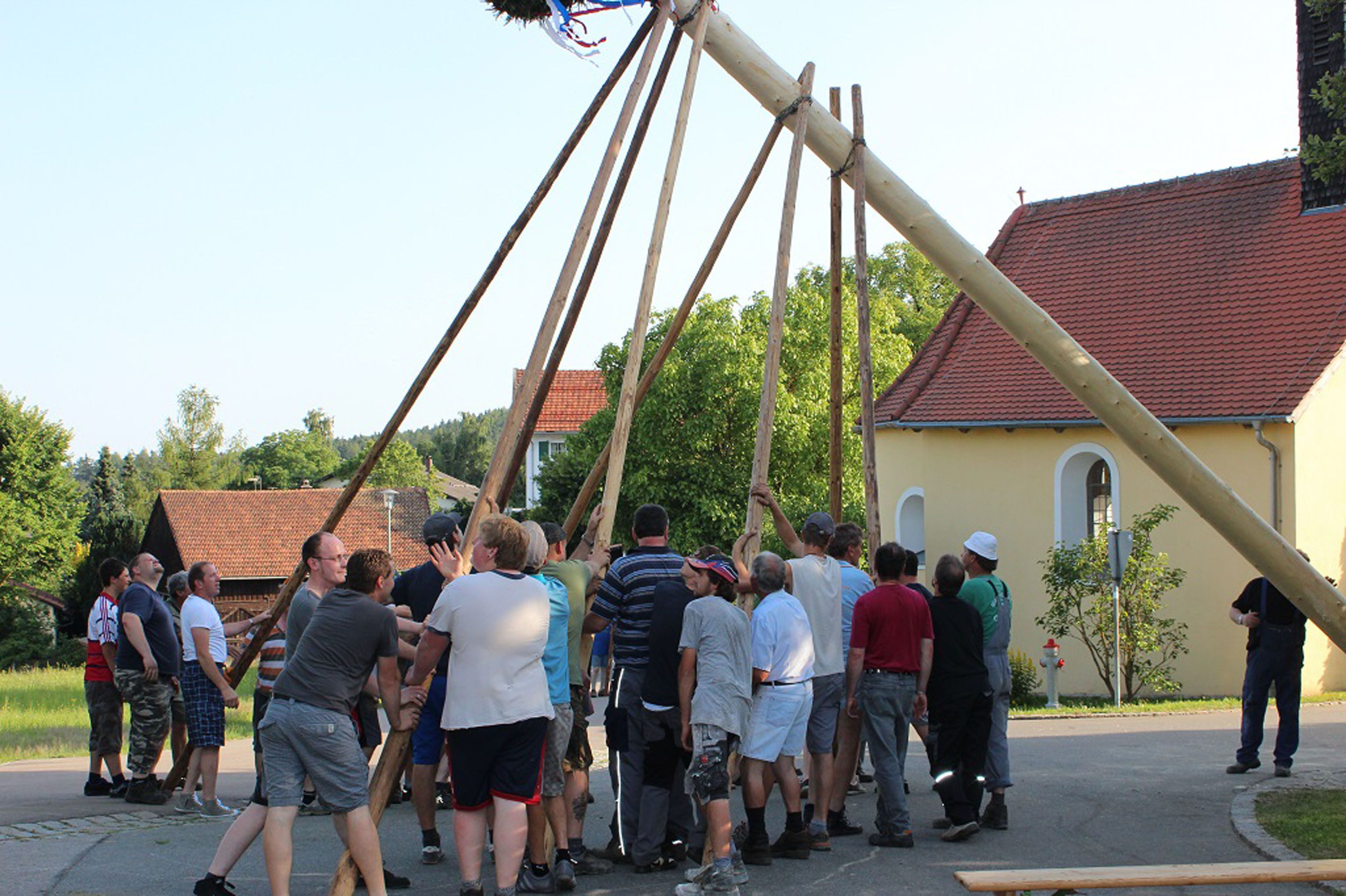 A group of people gathered around a large wooden structure outdoors.