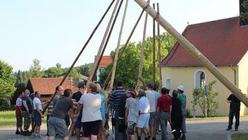 A group of people gathered around a large wooden structure outdoors.