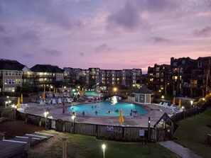 Et boligkompleks med swimmingpool, liggestole og en pavillon.