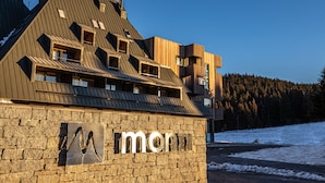A modern building with a stone facade and a sign that reads "monti". - Hotel Monti Spa&Wellness (Hadzici)