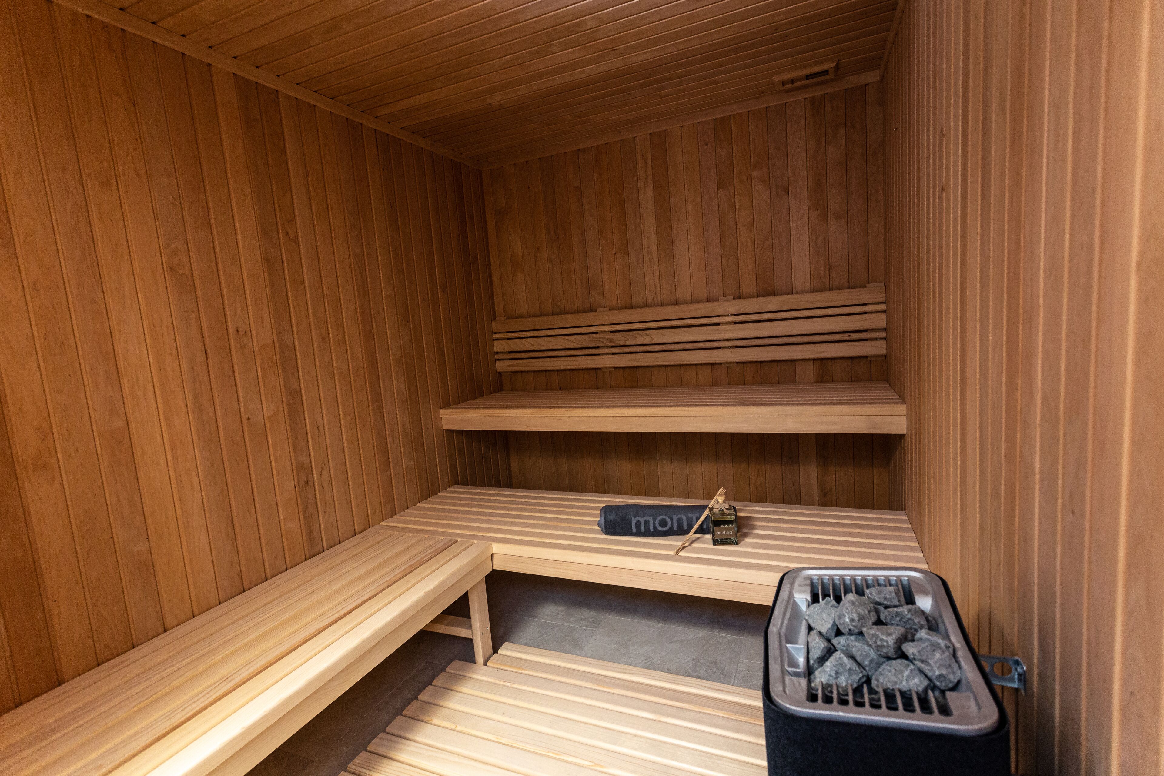 A sauna with wooden benches and a bench with a towel.