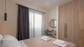 Una camera d'albergo con un letto, una scrivania con una sedia, un armadio e una finestra con tende.