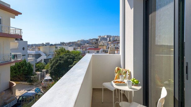 Un balcone con tavolo, sedie e vista sulla città.