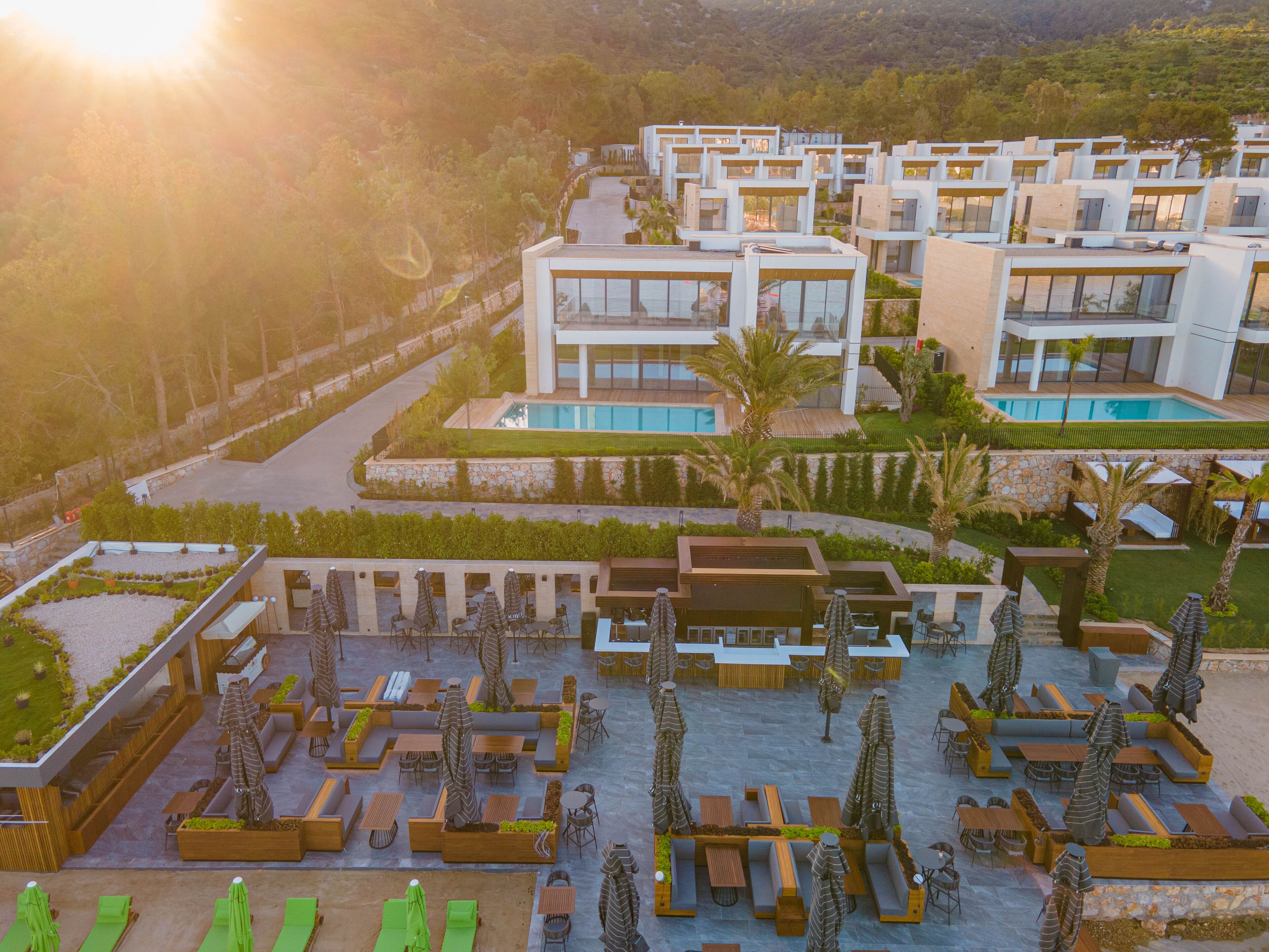 Um resort moderno com vários edifícios, áreas de estar ao ar livre e uma piscina.