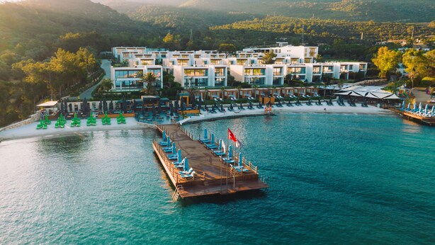Ein Resort mit Pool, Steg und Blick auf die umliegenden Hügel.
