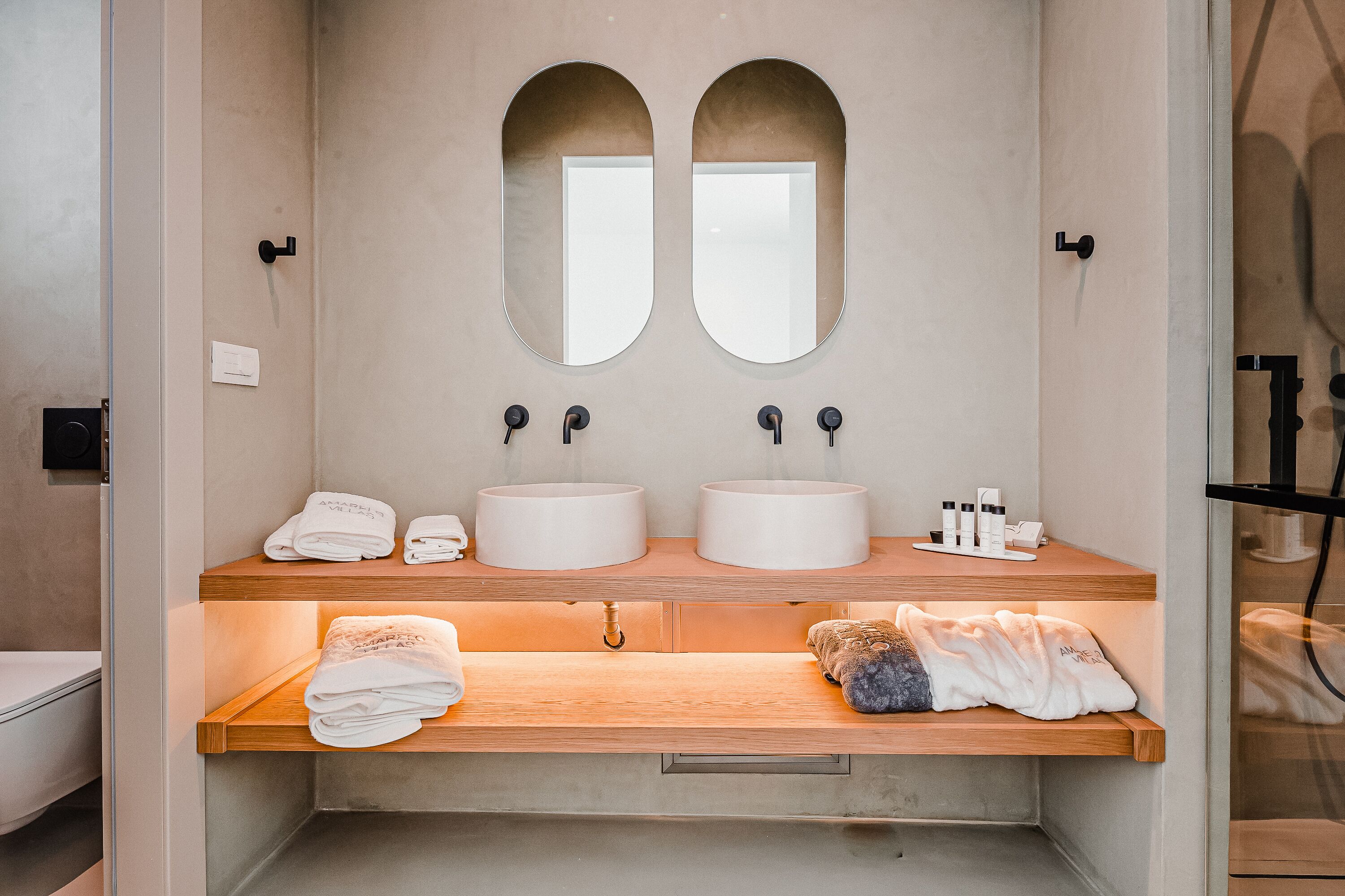 A bathroom with two sinks, a mirror, and a towel rack.