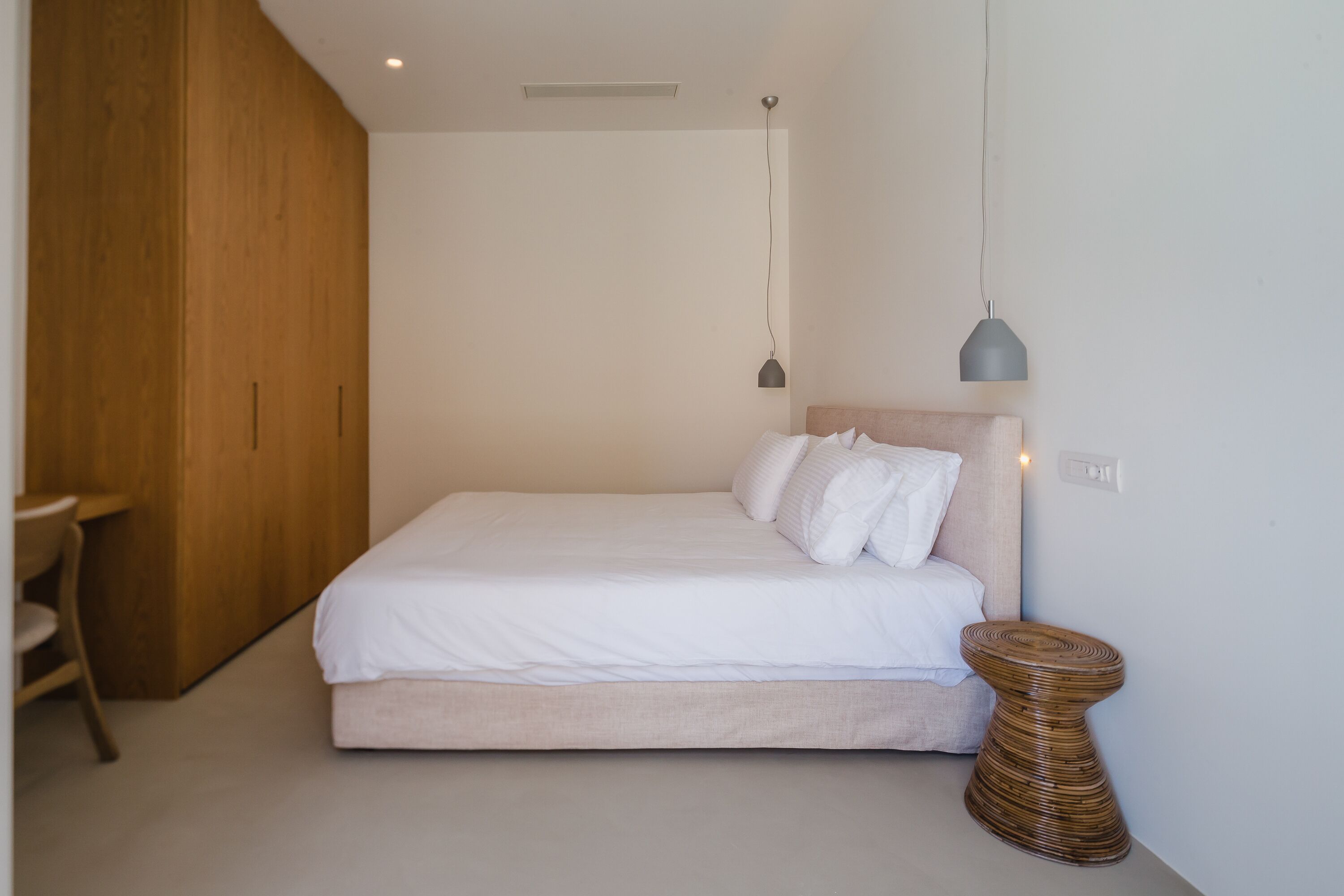Una camera da letto con un letto, un comodino e un'armadio in legno.