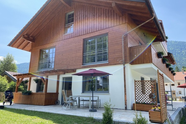 Terrasse mit Gartenmöbeln, Sonnenschirm und Grill