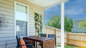 A covered patio with a wooden table and chairs, a white railing, and a wooden fence. - Carowinds 2Miles, Fully Fenced Yard, 2,000sq ft House, 5Min Highway (Charlotte)