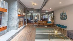 A spacious living area with a fireplace, a sofa, a coffee table, and a large window providing natural light. - ♥ Mission Ridge Midcentury - Family Friendly - Valley Views -  High Speed Wifi (Rossville)