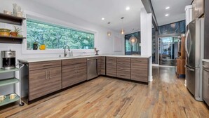 A modern kitchen with wooden cabinets, a large window, and a view of trees. - ♥ Mission Ridge Midcentury - Family Friendly - Valley Views -  High Speed Wifi (Rossville)