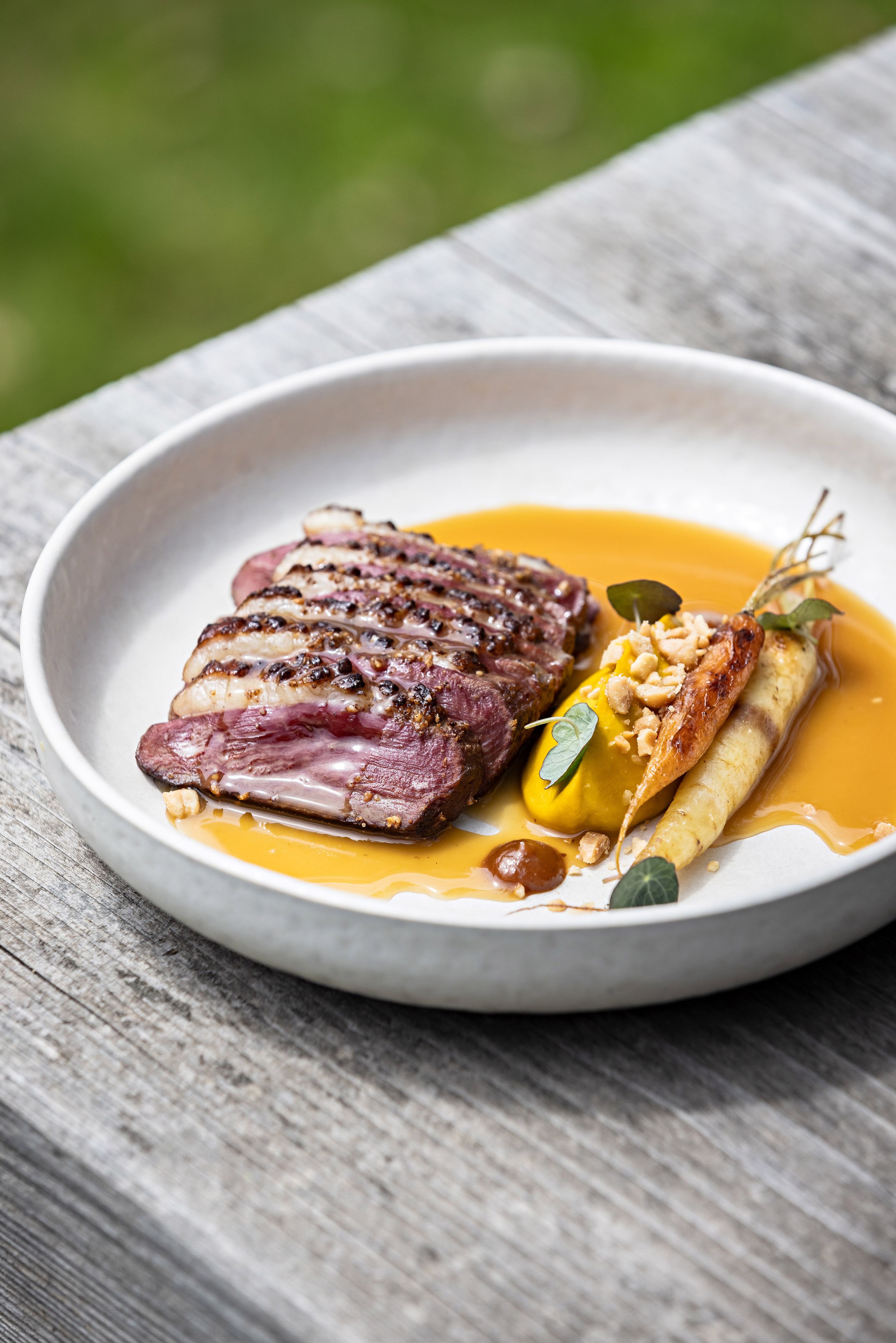 Ein Teller Essen mit einem Steak und Gemüse auf einer Holztisch.